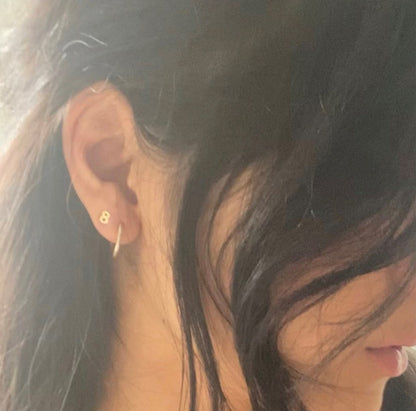 Close-up of an ear with a gold earring and hair.